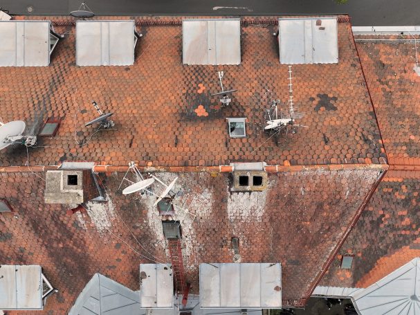 Dachansicht mit Ziegeln, Kamin und Luftkonditionierern.